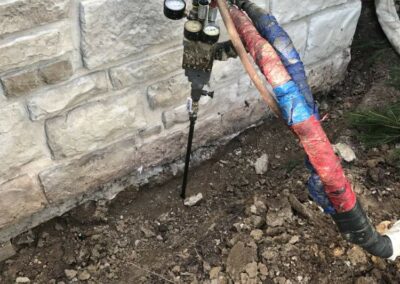 Deep foam injection to level a house foundation outside the home