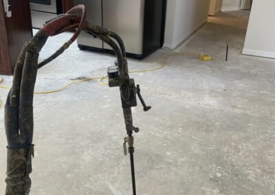 Deep foam injection being done in concrete floor inside home