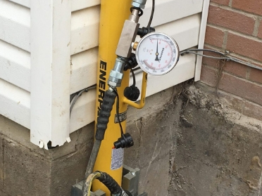 Close up of device being used as part of foundation repair